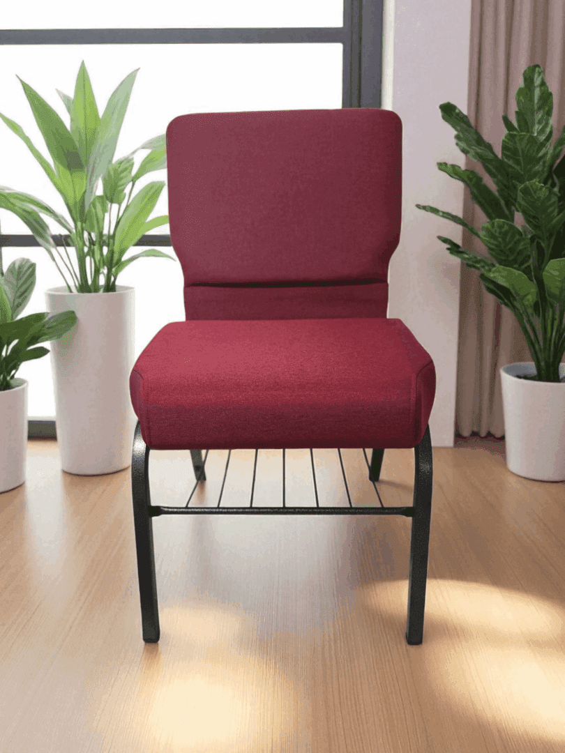 A red cushioned chair with a black metal frame between two potted plants.