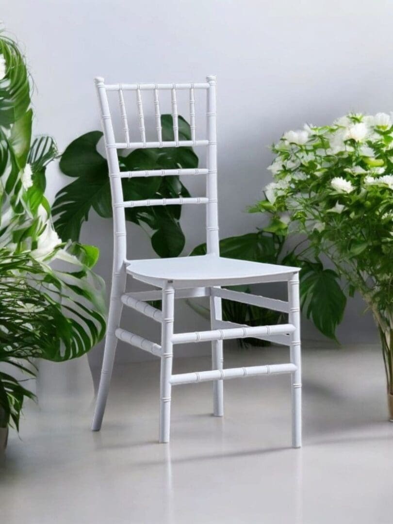 White wooden chair surrounded by lush green plants.