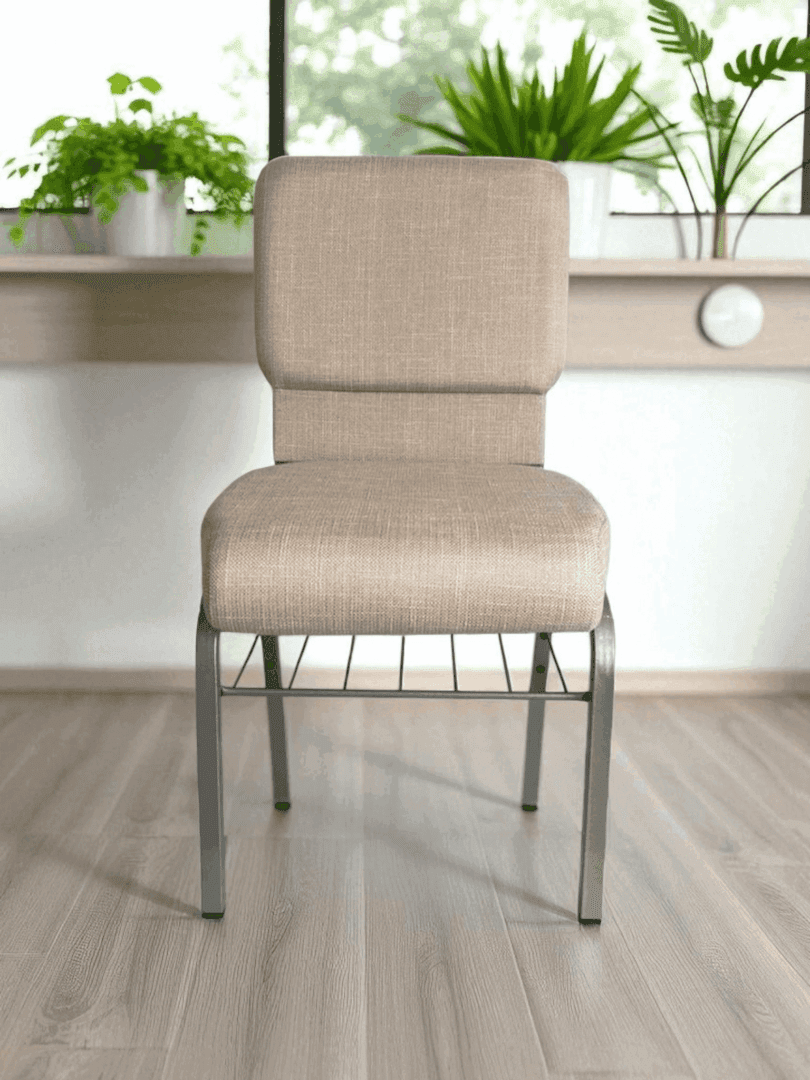 A beige cushioned chair with metal legs in a bright room.