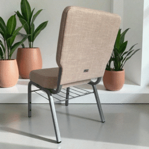 A modern chair with gray upholstery and metal legs near potted plants.